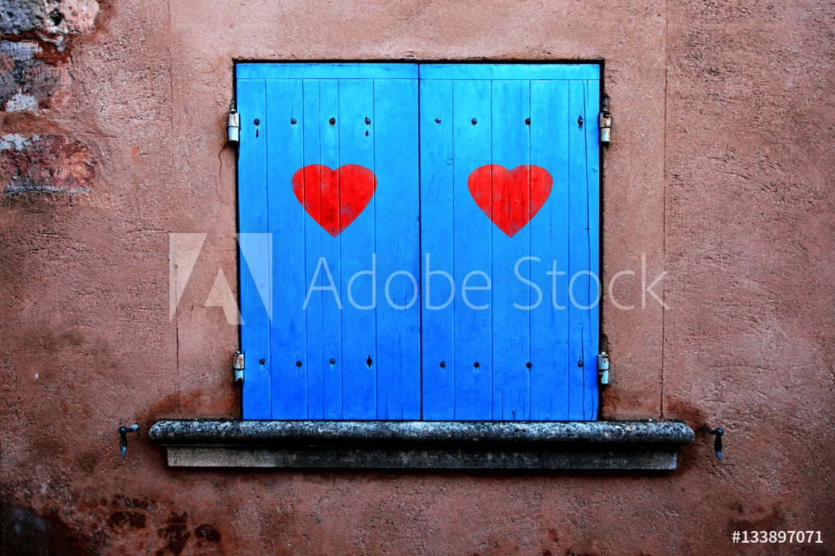 Afbeeldingen van Old blue colored closed window shutters details with illustrated two red hearts